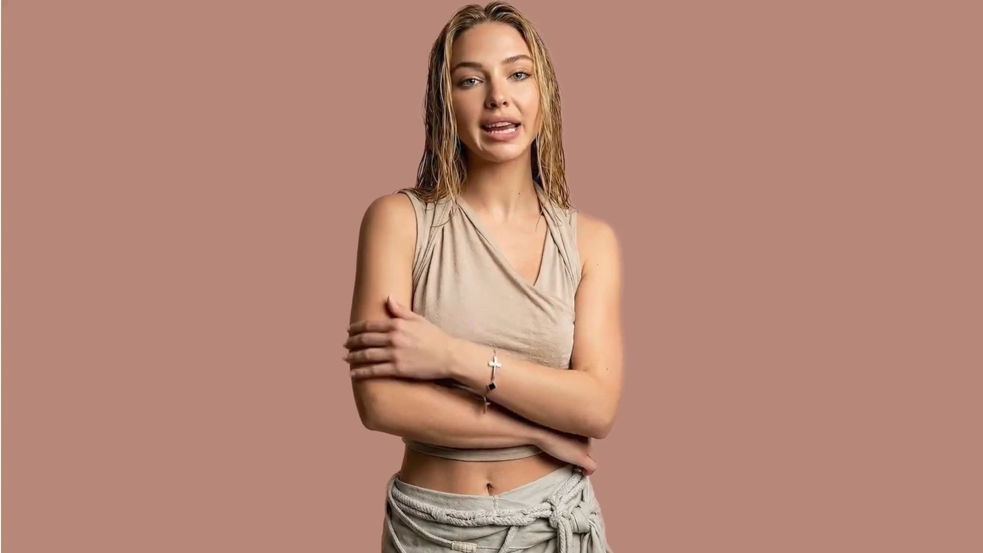 Model wearing Nano Faith jewelry against a blush background