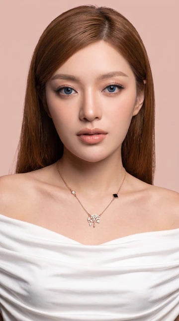 Nano Faith model photograph 2: a necklace styled with a white top against a blush background