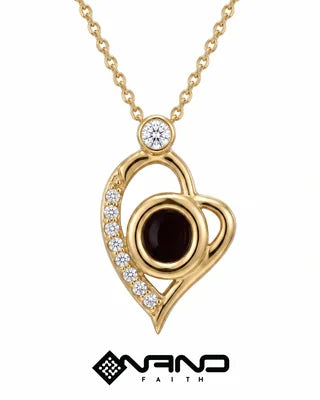 Open gold heart pendant with a dark center and a line of clear stones